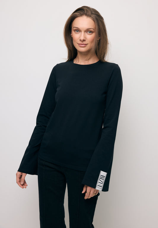 Zbliżenie na modelkę w dzianinowym longsleeve BELUNNA w kolorze czarnym.