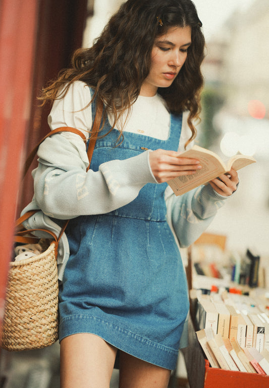 Uśmiechnięta modelka ubrana w jeansową mini sukienkę NARBONA na białym T-shircie SEYA.