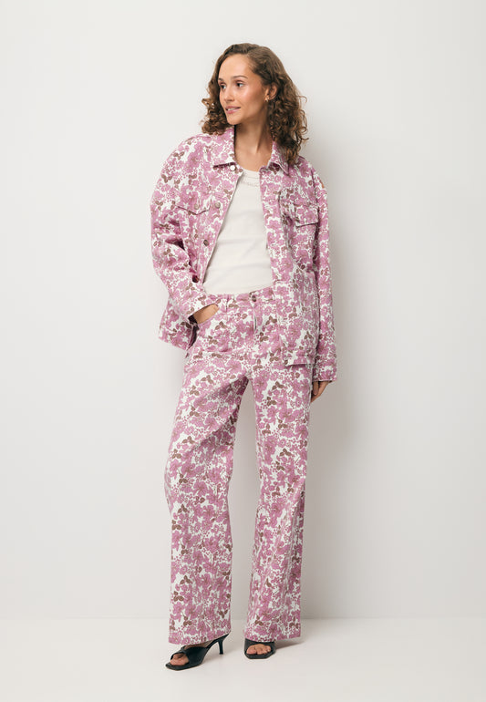 Modelka ubrana w printowane spodnie DONY, kremowy top SEYA oraz denimową kurtkę w print PRINSA.