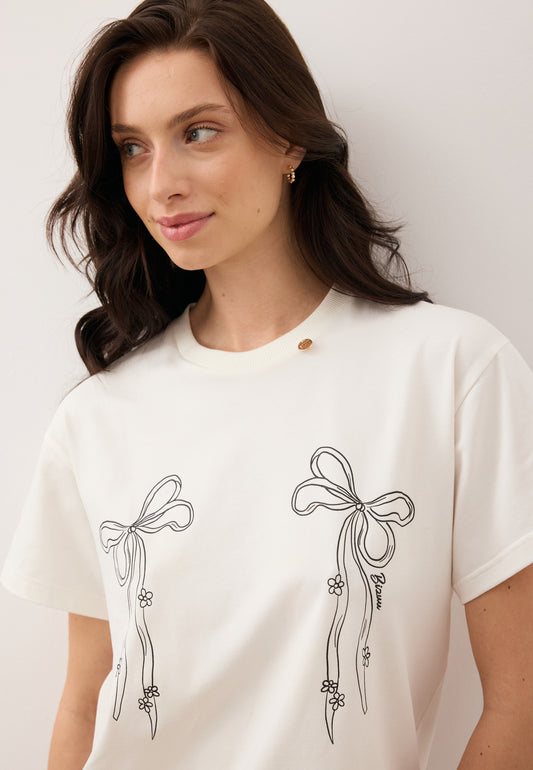 Zbliżenie na modelkę ubraną w T-shirt z rysunkiem kokardek BOW.