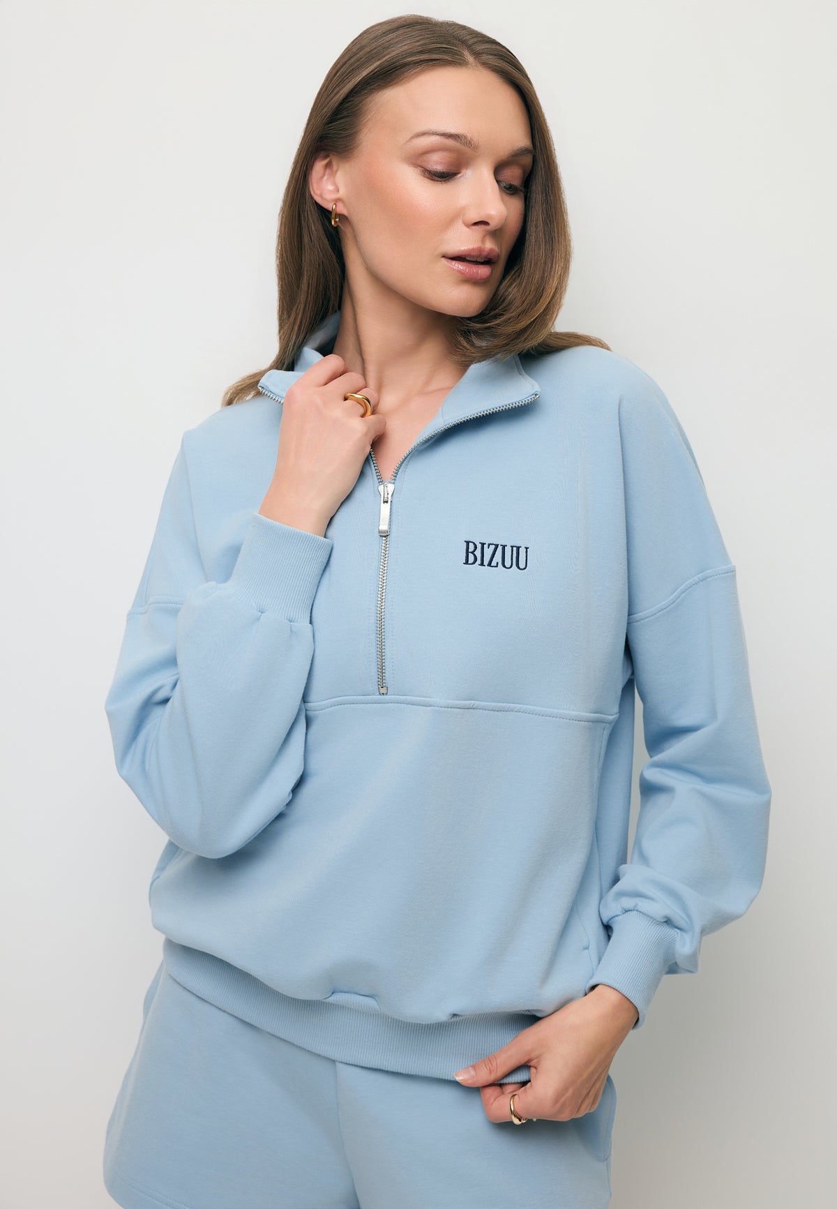 Zbliżenie na modelkę w błękitnej bluzie dresowej CHAMP.