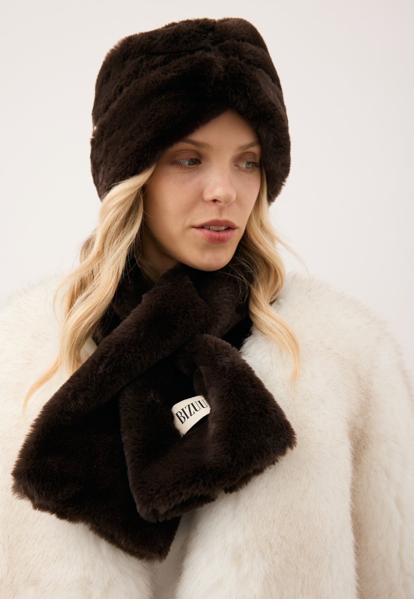Zbliżenie na modelkę w brązowym szaliku z futra FLUFFY oraz futrzanej opasce FEMI.